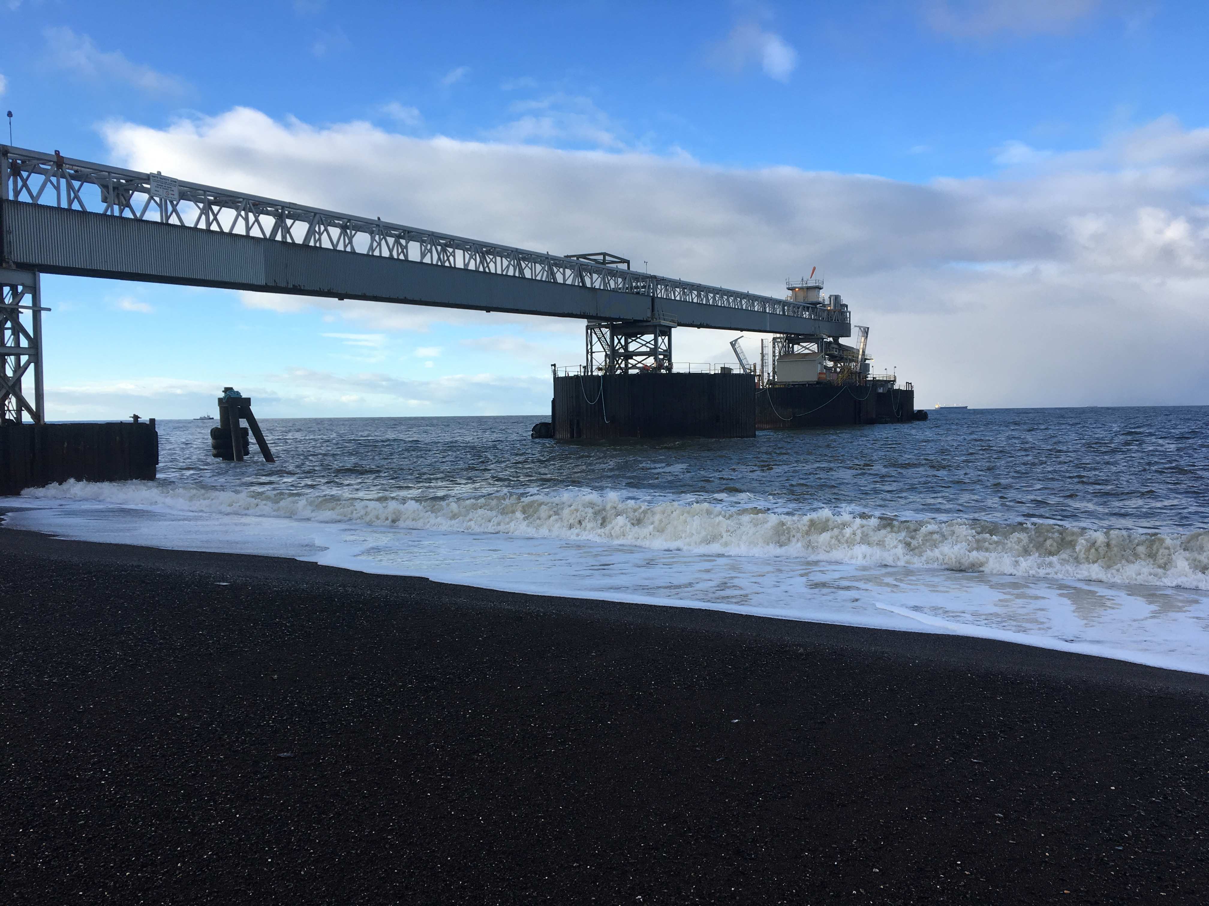 Marine conveyor trestle extending over the ocean at a remote bulk terminal